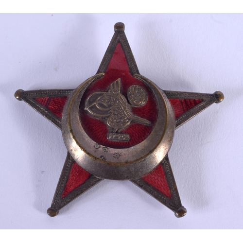 811 - AN UNUSUAL MIDDLE EASTERN BRASS AND ENAMEL STAR BADGE. 4.5 cm wide.