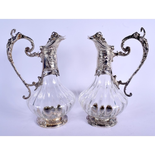 851 - A PAIR OF ART NOUVEAU SILVER PLATED CLARET JUGS overlaid with fish and vines. 27 cm high.