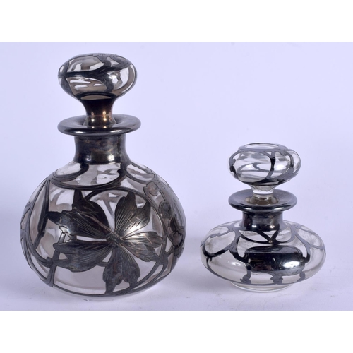 935 - TWO SILVER OVERLAID GLASS SCENT BOTTLES. Largest 11 cm high. (2)