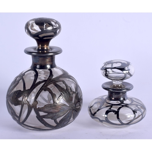 935 - TWO SILVER OVERLAID GLASS SCENT BOTTLES. Largest 11 cm high. (2)