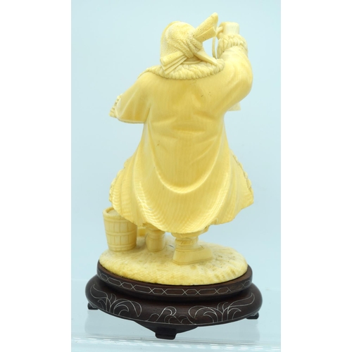 31 - AN EARLY 20TH CENTURY CHINESE CARVED CULTURAL REVOLUTION IVORY modelled roaming holding grain holdin... 