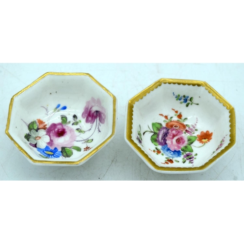 32 - A PAIR OF EARLY 19TH CENTURY ENGLISH PORCELAIN SALTS painted with floral sprays. 6.5 cm wide.