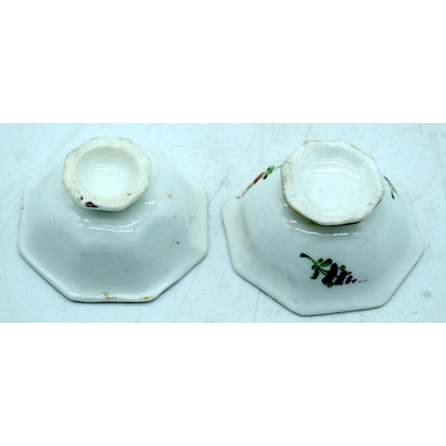 32 - A PAIR OF EARLY 19TH CENTURY ENGLISH PORCELAIN SALTS painted with floral sprays. 6.5 cm wide.
