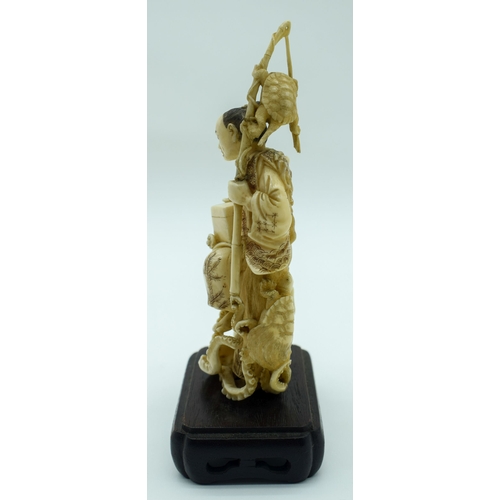 54 - A 19TH CENTURY JAPANESE MEIJI PERIOD CARVED IVORY OKIMONO modelled as a fisherman standing upon an o... 