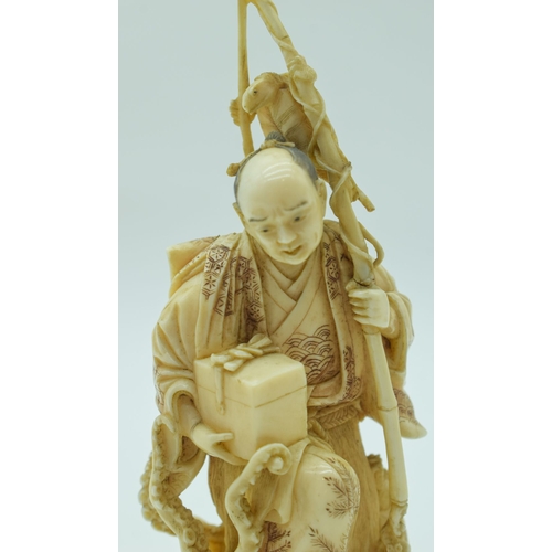 54 - A 19TH CENTURY JAPANESE MEIJI PERIOD CARVED IVORY OKIMONO modelled as a fisherman standing upon an o... 