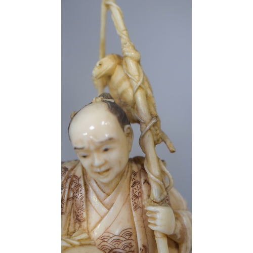 54 - A 19TH CENTURY JAPANESE MEIJI PERIOD CARVED IVORY OKIMONO modelled as a fisherman standing upon an o... 