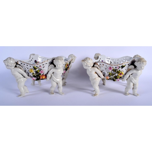 131 - A PAIR OF 19TH CENTURY GERMAN PORCELAIN OPENWORK FRUIT BASKETS modelled with four putti holding alof... 