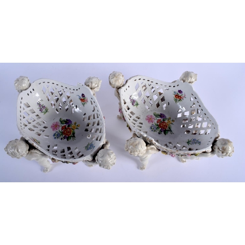 131 - A PAIR OF 19TH CENTURY GERMAN PORCELAIN OPENWORK FRUIT BASKETS modelled with four putti holding alof... 