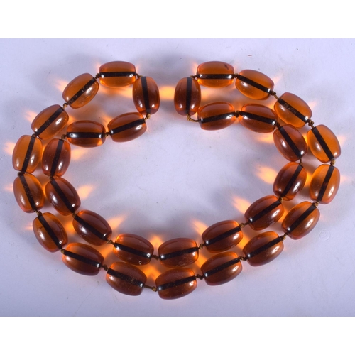 1340 - A LARGE AMBER TYPE NECKLACE. 200 grams. 88 cm long, largest bead 2.75 cm wide.