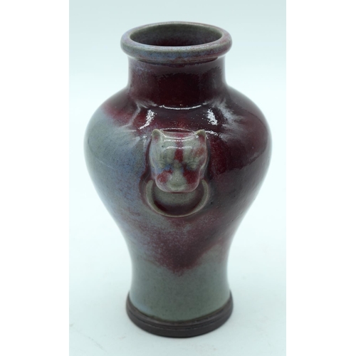 3160 - A Chinese Flambe glazed vase with Lion head handles 18cm.