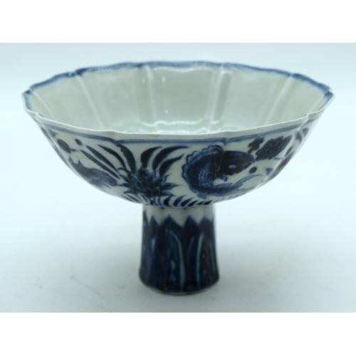 3161 - A Chinese blue and white stem cup decorated with fish. 17 x 11cm.