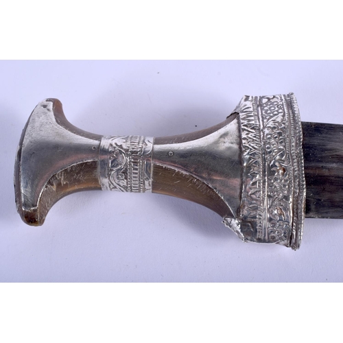 481 - A 19TH CENTURY MIDDLE EASTERN OMANI CARVED RHINOCEROS HORN HANDLED JAMBIYA DAGGER overlaid in silver... 