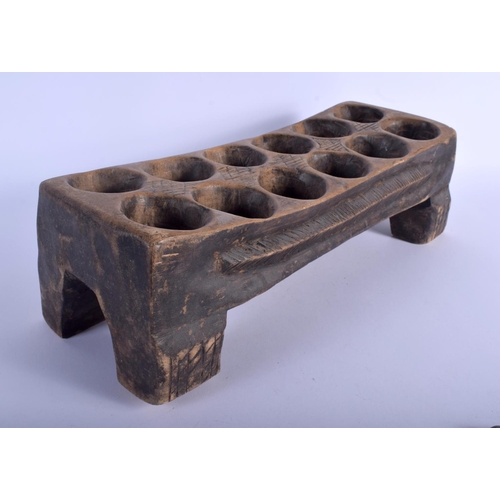 539 - AN AFRICAN MANGALA CARVED WOOD GAMING BOARD with counters. 44 cm x 14 cm. (qty)