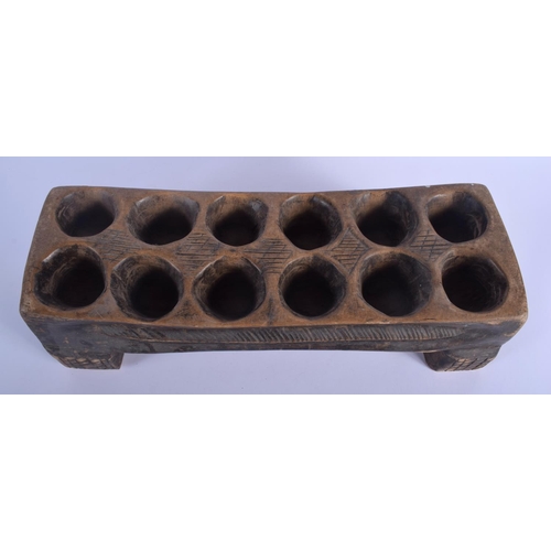 539 - AN AFRICAN MANGALA CARVED WOOD GAMING BOARD with counters. 44 cm x 14 cm. (qty)