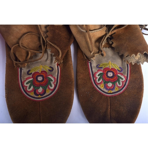 592 - A PAIR OF NORTH AMERICAN TRIBAL MOCCASINS together with a sash and two gourd nuts. (5)