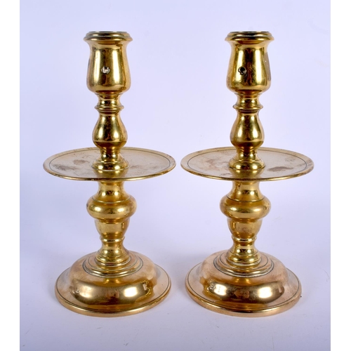 596 - A PAIR OF 18TH CENTURY EUROPEAN BRASS CANDLESTICKS with circular drip trays. 23 cm high.