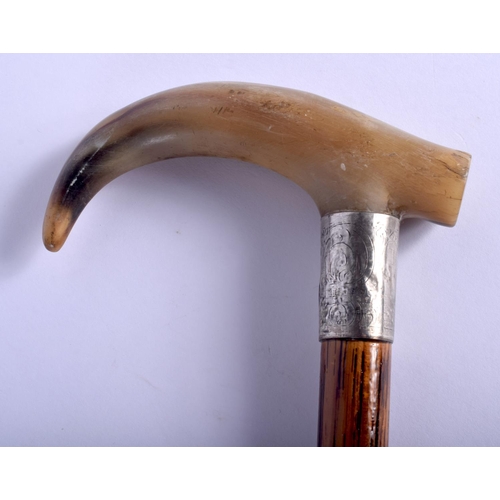 606 - A 19TH CENTURY CONTINENTAL CARVED BUFFALO HORN WALKING CANE with silver mounts. 88 cm long.