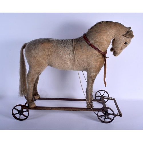 666 - AN EARLY 20TH CENTURY CHILDS PLUSH HORSE PULL ALONG TOY. 60 cm x 54 cm.