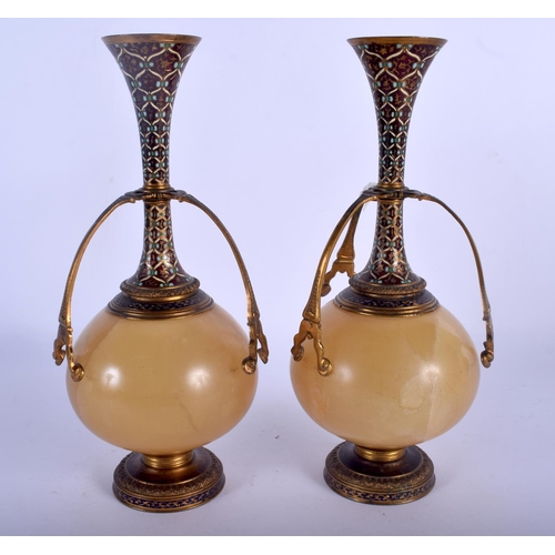 673 - A PAIR OF 19TH CENTURY FRENCH CHAMPLEVE ENAMEL AND ONYX VASES decorated with motifs. 24.5 cm high.