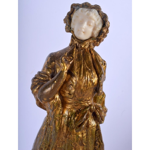 740 - AN ART NOUVEAU BRONZE AND IVORY FIGURE OF A FEMALE modelled with one finger raised upon a triangular... 