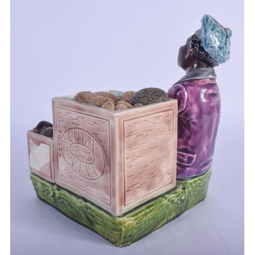 762 - AN UNUSUAL EUROPEAN PAINTED POTTERY FIGURE OF A CUBAN modelled beside 2 crates of fruit. 15 cm x 12 ... 