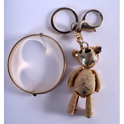 869 - A 9CT GOLD PLATED BANGLE and a teddy charm. 75 grams. Largest 8 cm wide. (2)