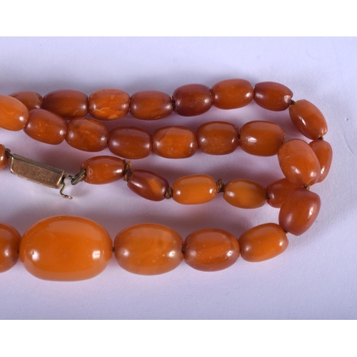 883 - A VINTAGE BUTTERSCOTCH AMBER NECKLACE. 13 grams. 42 cm long, largest bead 1.5 cm wide.