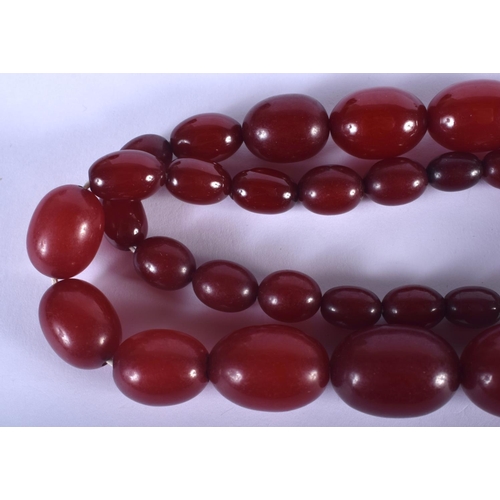 885 - A VINTAGE CHERRY AMBER BAKELITE NECKLACE. 53 grams. 48 cm long, largest 2.5 cm wide.