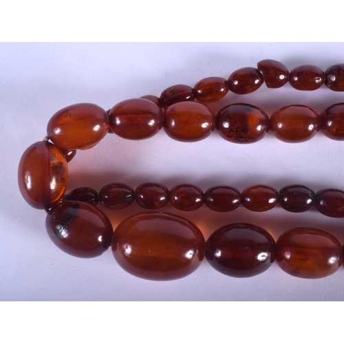 905 - A VINTAGE AMBER TYPE NECKLACE. 31 grams. 56 cm long, largest bead 1.5 cm x 1 cm.