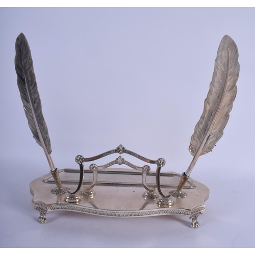 977 - AN EARLY 20TH CENTURY CONTINENTAL WHITE METAL INKWELL of scrolling form with 2 feather quills. 26 cm... 