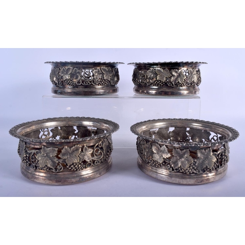 981 - A SET OF FOUR ANTIQUE SILVER PLATED VINE LEAF AND BERRY BOTTLE COASTERS. 16 cm x 6 cm. (4)