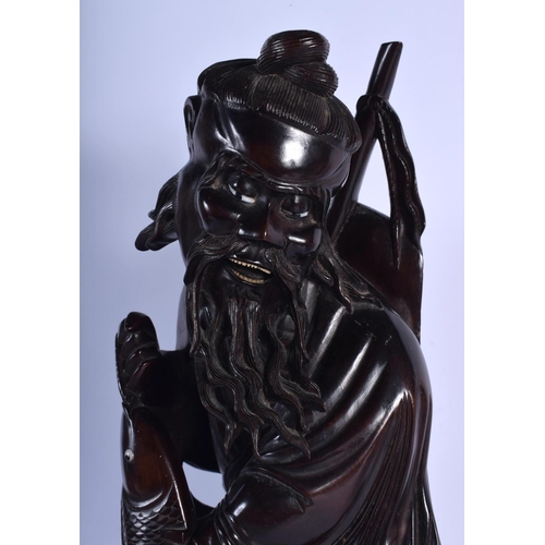 1542 - A VERY LARGE 19TH CENTURY CHINESE CARVED HARDWOOD FIGURE OF A FISHERMAN Qing, modelled holding a fis... 