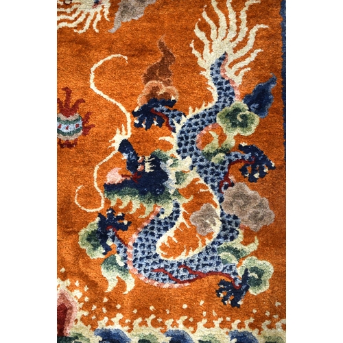 1593 - AN EARLY 20TH CENTURY CHINESE SILK WORK DRAGON PILLAR CARPET decorated upon a orange ground. 192 cm ... 