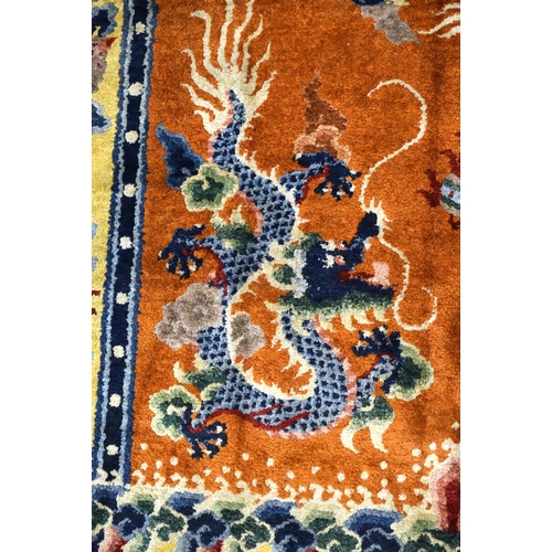 1593 - AN EARLY 20TH CENTURY CHINESE SILK WORK DRAGON PILLAR CARPET decorated upon a orange ground. 192 cm ... 