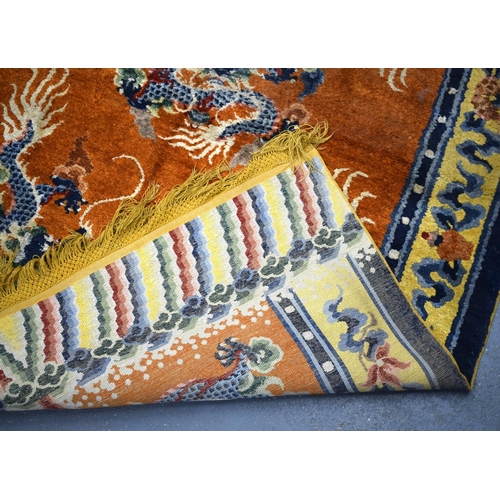 1593 - AN EARLY 20TH CENTURY CHINESE SILK WORK DRAGON PILLAR CARPET decorated upon a orange ground. 192 cm ... 