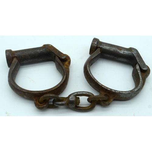 2545 - An antique pair of iron handcuffs 24cm.