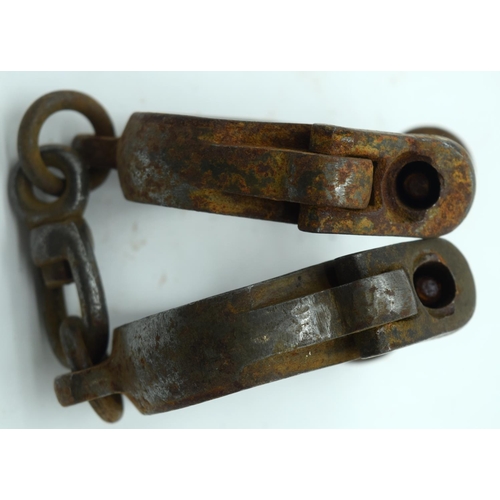 2545 - An antique pair of iron handcuffs 24cm.