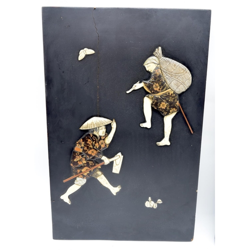 2561 - A pair of Japanese wooden panels decorated with carved Ivory figures 39 x 25cm (2)
