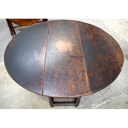 2569 - AN 18TH CENTURY OAK GATELEG DINING TABLE upon cylindrical supports. 118 cm x 70 cm extended.