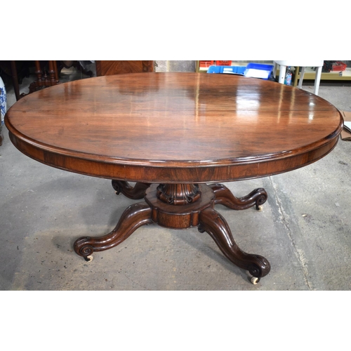 2588 - A LARGE VICTORIAN ROSEWOOD BREAKFAST TABLE upon a scrolling acanthus capped base. 148 cm x 73 cm.