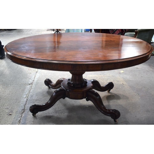 2588 - A LARGE VICTORIAN ROSEWOOD BREAKFAST TABLE upon a scrolling acanthus capped base. 148 cm x 73 cm.