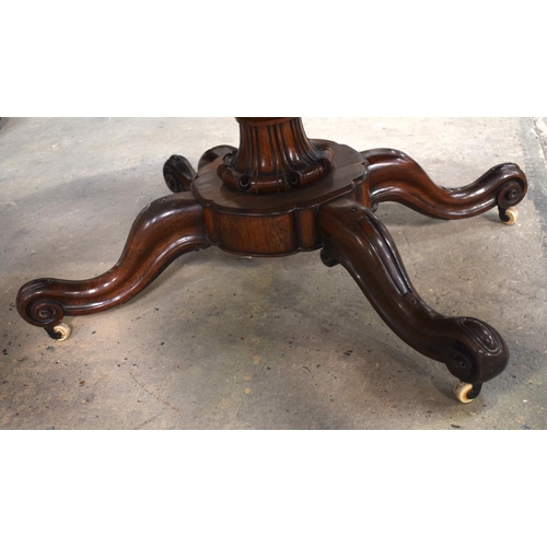 2588 - A LARGE VICTORIAN ROSEWOOD BREAKFAST TABLE upon a scrolling acanthus capped base. 148 cm x 73 cm.