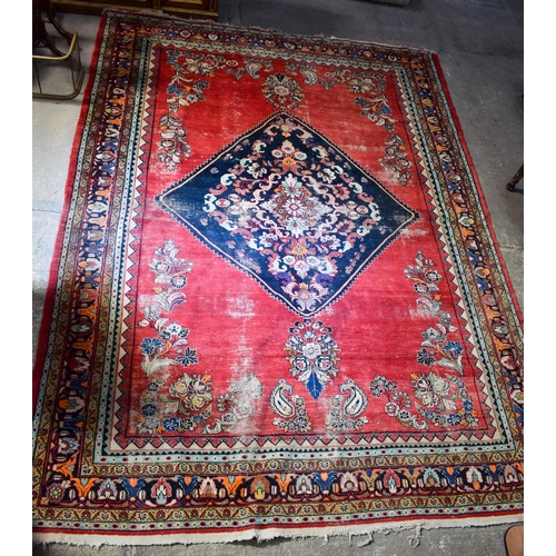 2601 - A LARGE MIDDLE EASTERN RED GROUND CARPET decorated with a blue lozenge of flowers. 354 cm x 264 cm.
