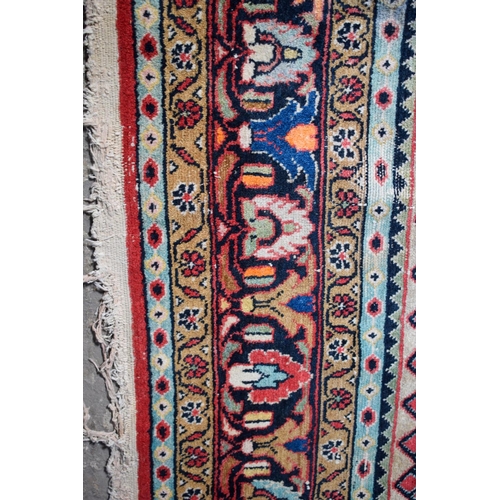 2601 - A LARGE MIDDLE EASTERN RED GROUND CARPET decorated with a blue lozenge of flowers. 354 cm x 264 cm.