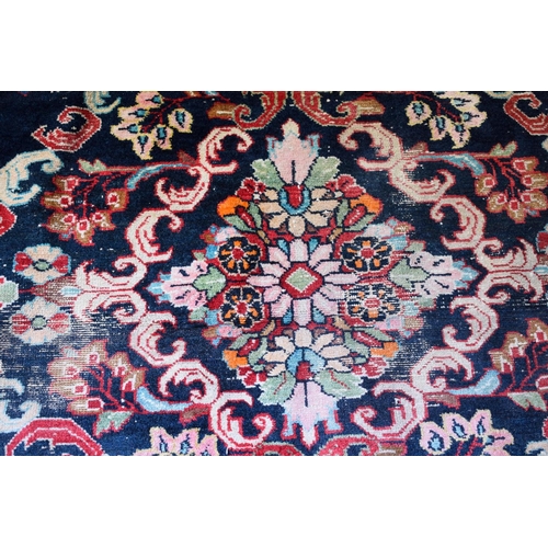 2601 - A LARGE MIDDLE EASTERN RED GROUND CARPET decorated with a blue lozenge of flowers. 354 cm x 264 cm.