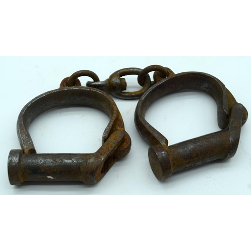 2545 - An antique pair of iron handcuffs 24cm.