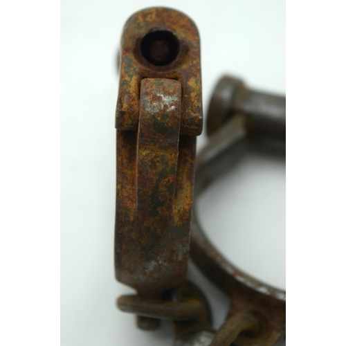 2545 - An antique pair of iron handcuffs 24cm.