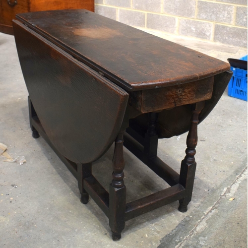 2569 - AN 18TH CENTURY OAK GATELEG DINING TABLE upon cylindrical supports. 118 cm x 70 cm extended.
