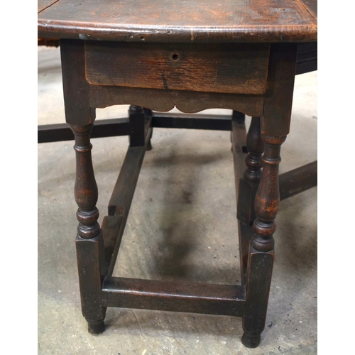 2569 - AN 18TH CENTURY OAK GATELEG DINING TABLE upon cylindrical supports. 118 cm x 70 cm extended.