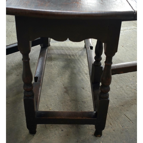 2569 - AN 18TH CENTURY OAK GATELEG DINING TABLE upon cylindrical supports. 118 cm x 70 cm extended.